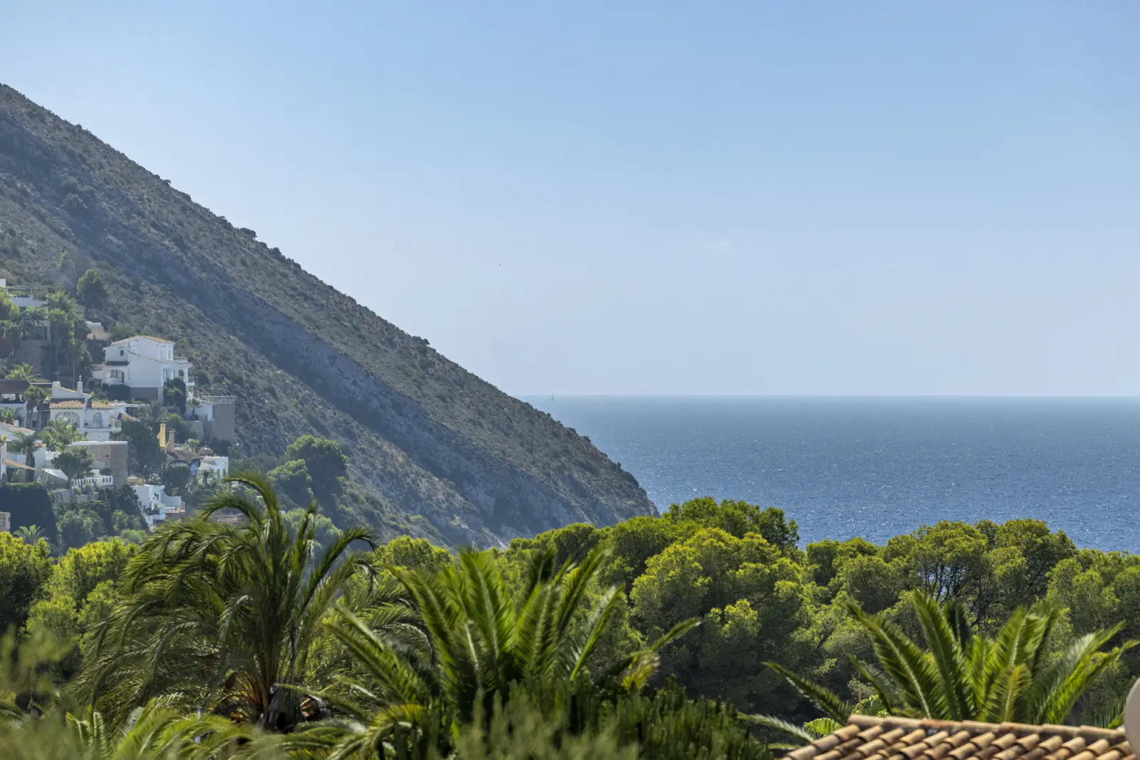 Sea view across the wooded coastline and hillside homes of El Portet
