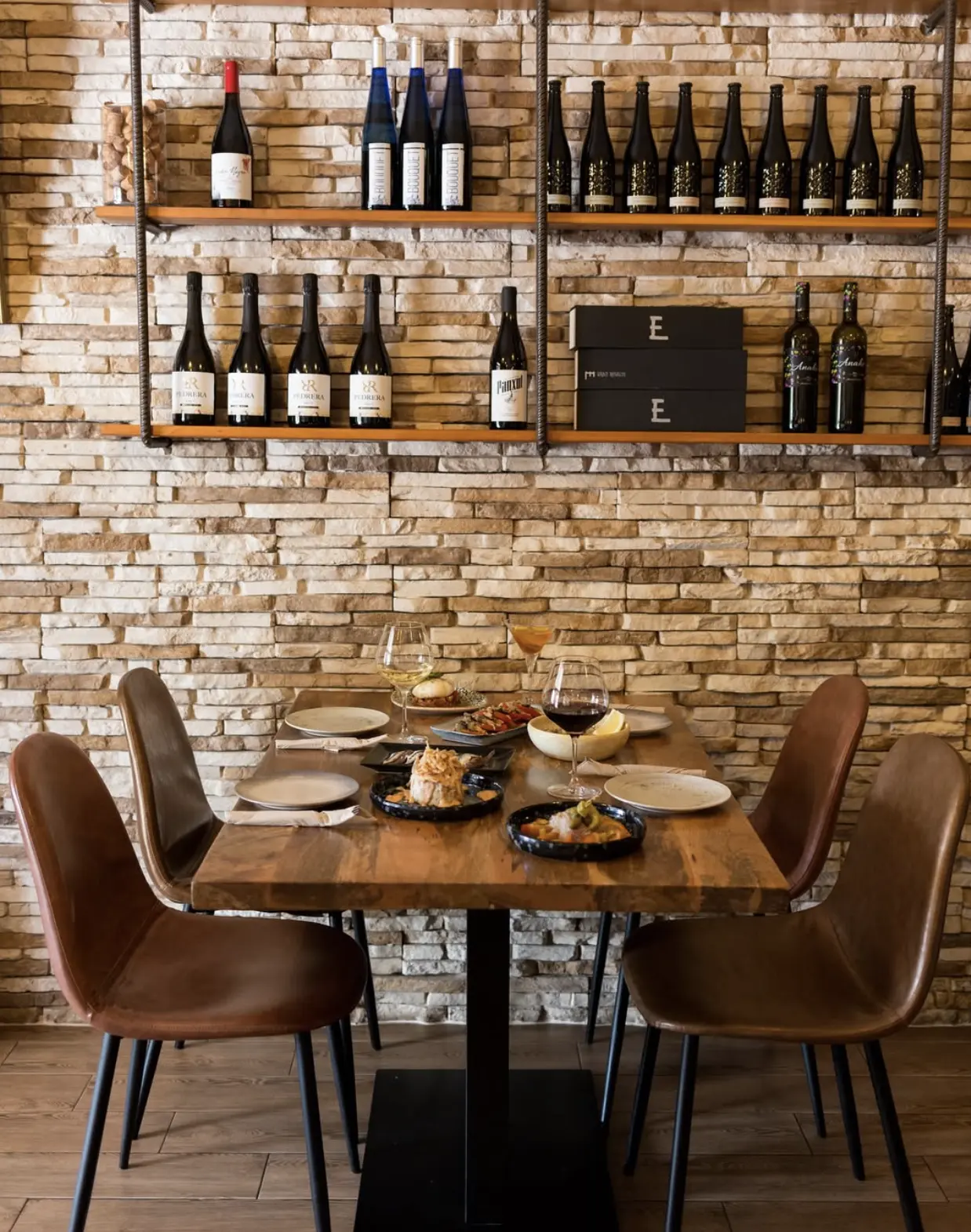 Dining area with a stone feature wall and wine display